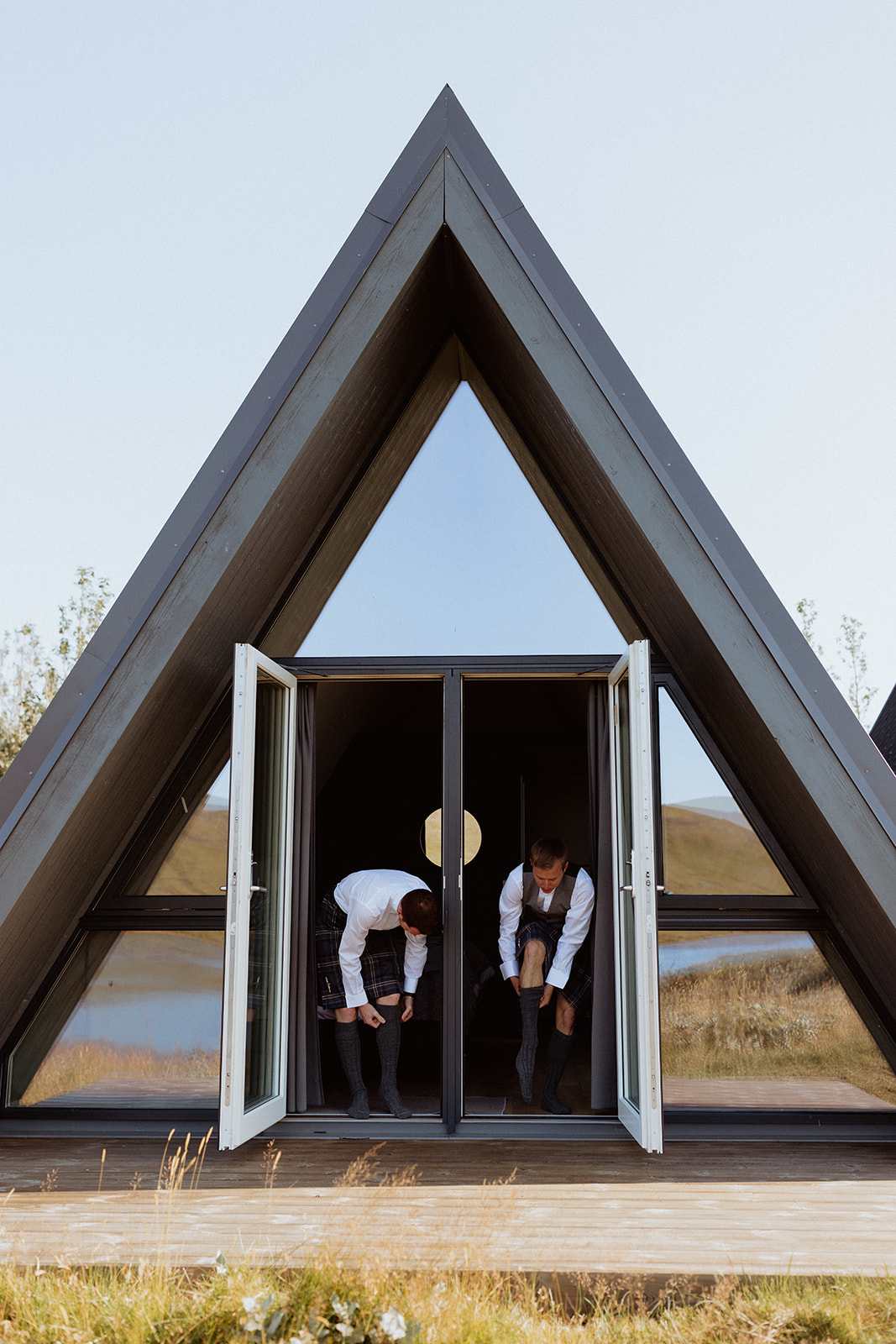 The groomsmen preparing inside the A-frame at Eirð Retreat, adjusting their suits and ties in the serene, rustic setting.