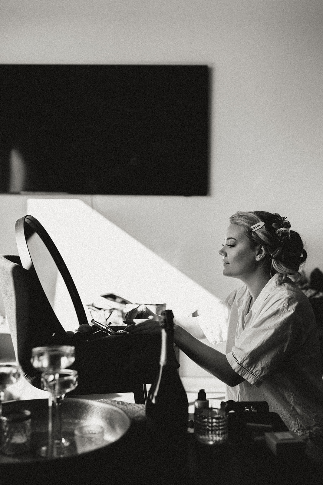 Bride carefully applying makeup at Eirð Retreat, getting ready for her elopement amidst the peaceful Icelandic surroundings.