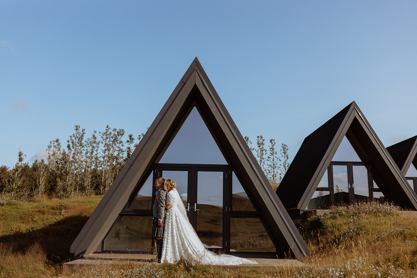 Emotional first look moment between the bride and groom in front of a beautiful A-frame cabin, captured during their Icelandic elopement