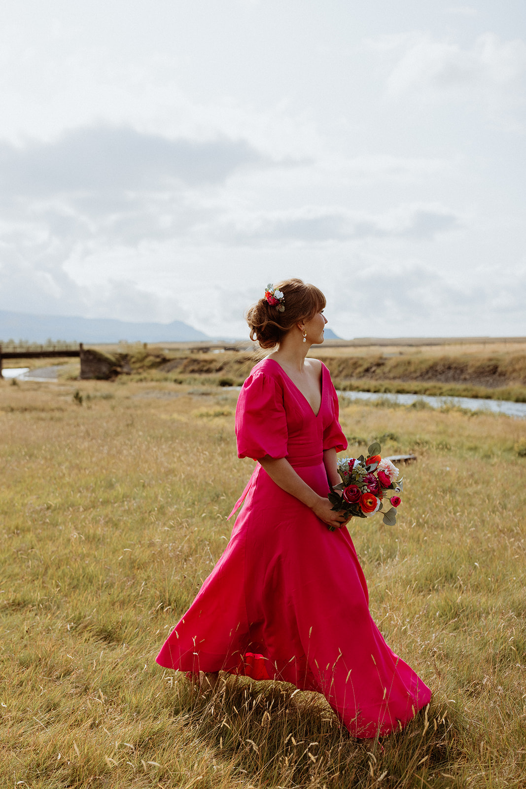Bridesmaid standing gracefully in her pink dress during the Icelandic elopement, ready for the ceremony at Gluggafoss waterfall.