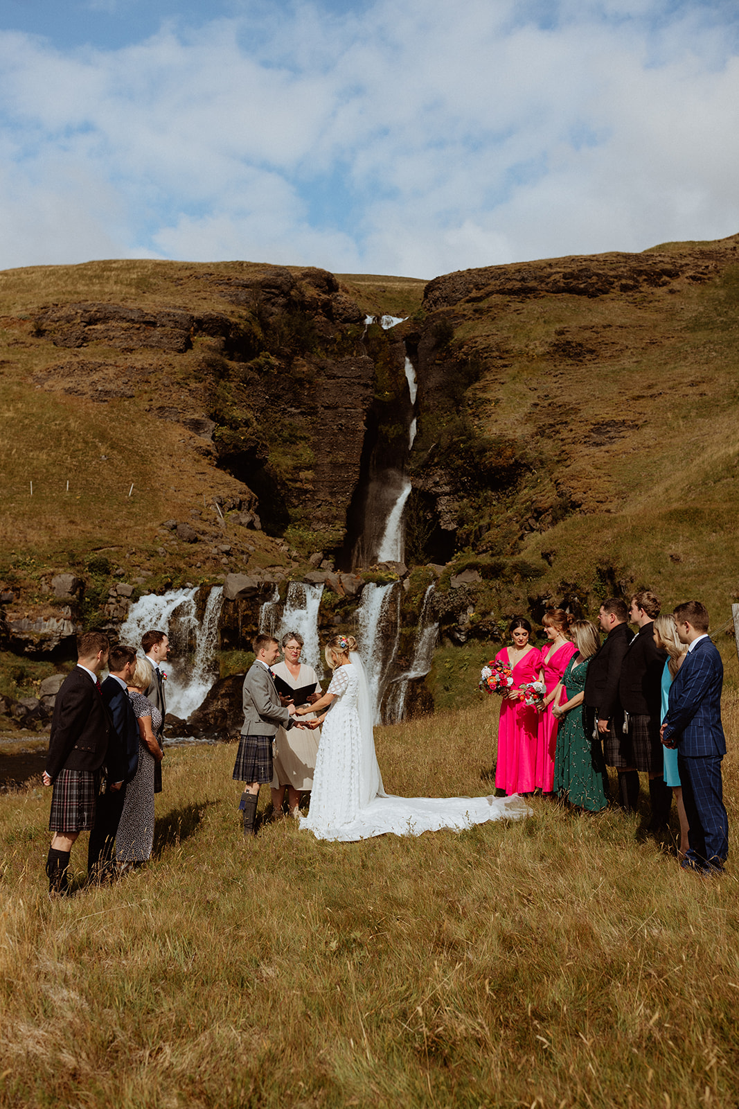 Bride and groom exchanging vows during their intimate elopement ceremony at Gluggafoss waterfall in Iceland.