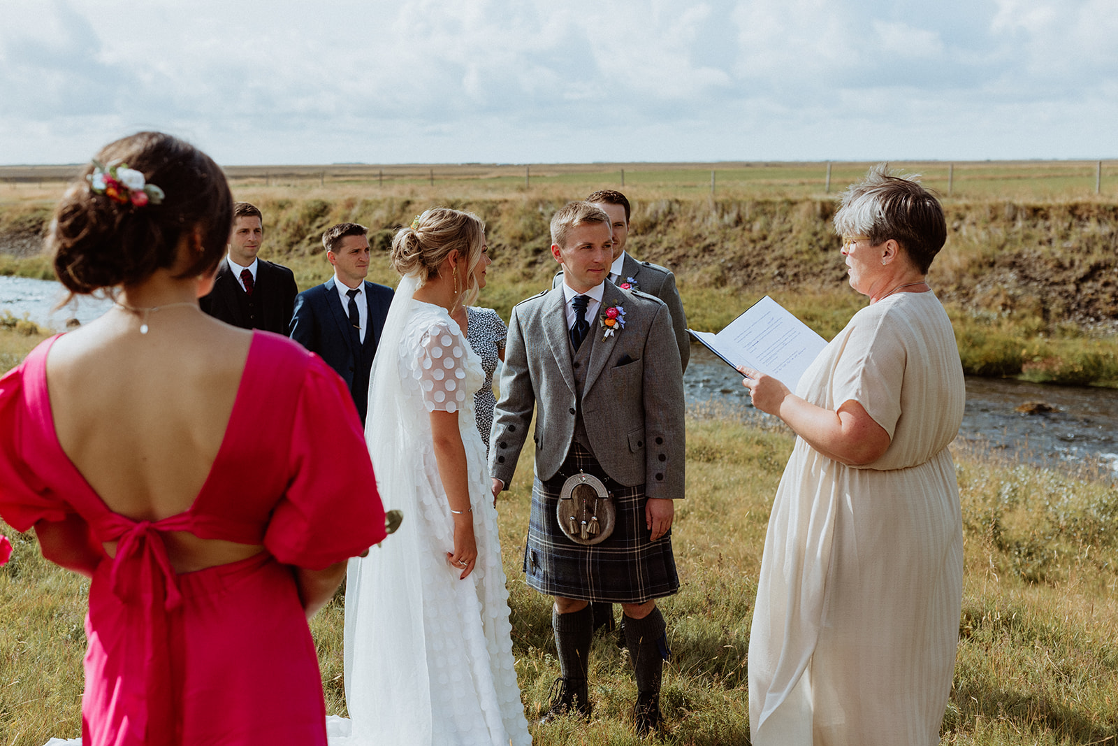 Intimate elopement ceremony at Gluggafoss waterfall in Iceland, where the bride and groom exchange vows amidst the dramatic landscape.