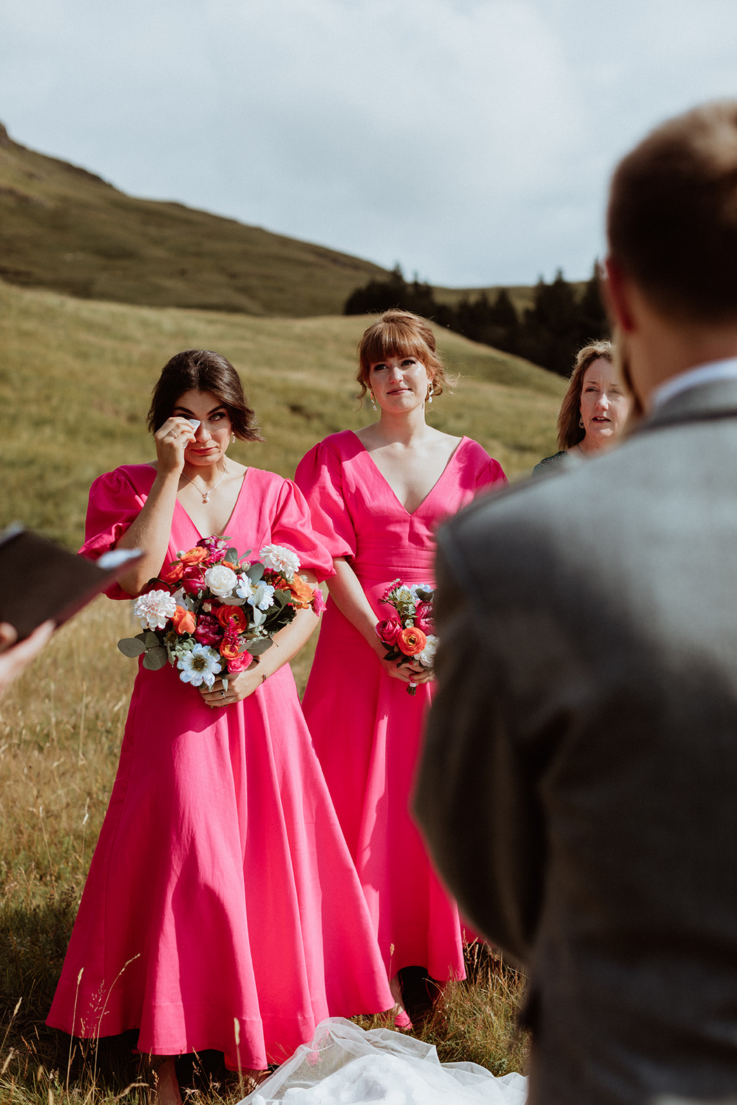 Tearful bridesmaid watching the couple exchange vows during their emotional Iceland elopement at Gluggafoss waterfall.