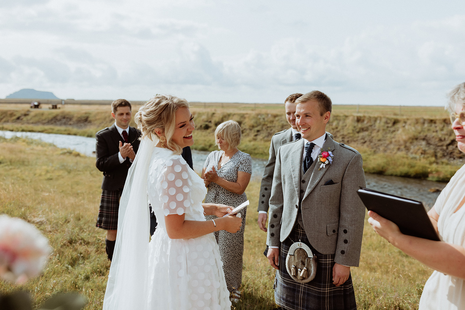 Bride and groom exchange heartfelt personal vows in front of Gluggafoss waterfall during their intimate Iceland elopement.