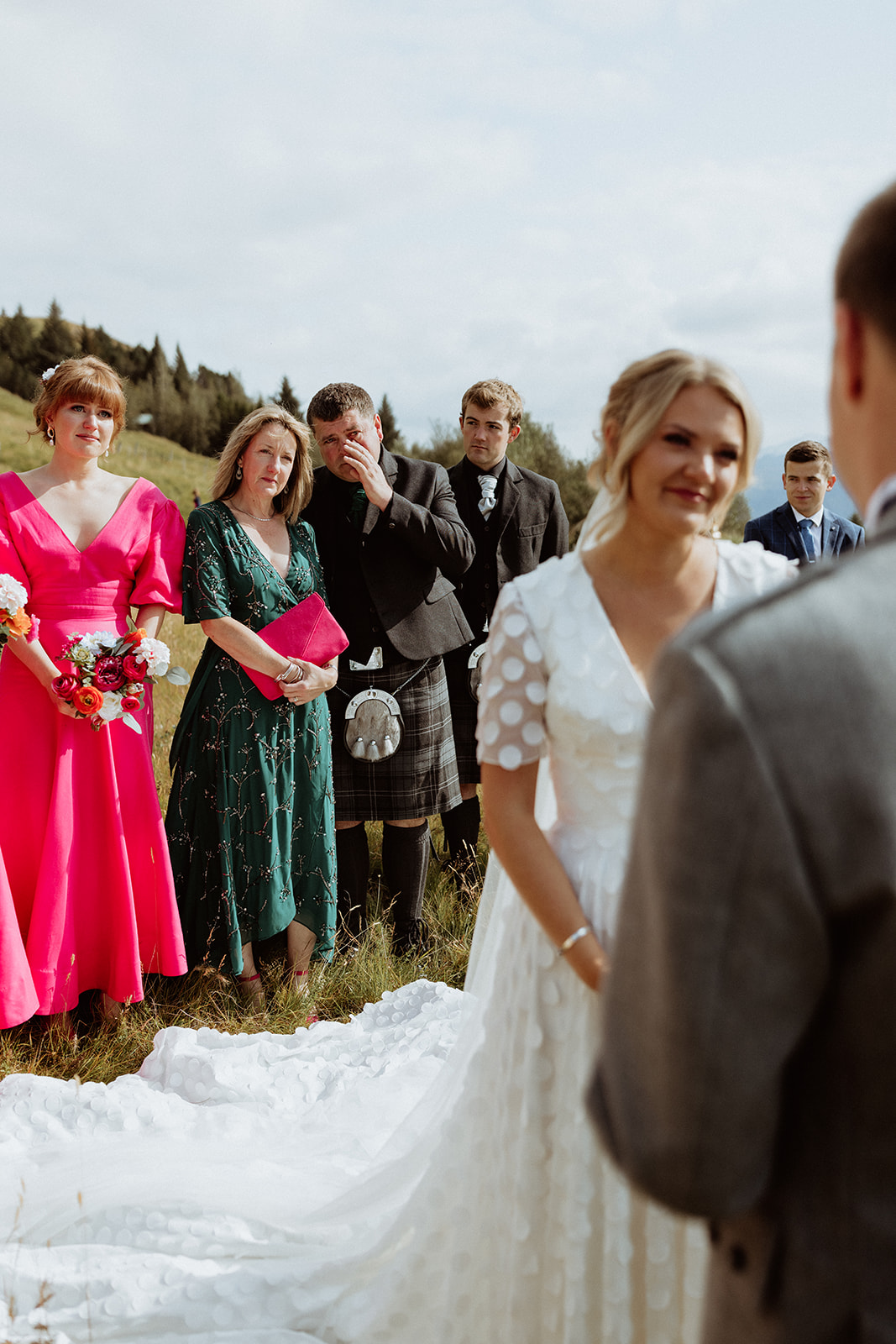 Emotional parents watching their daughter exchange vows during a heartfelt Iceland elopement ceremony at Gluggafoss waterfall.