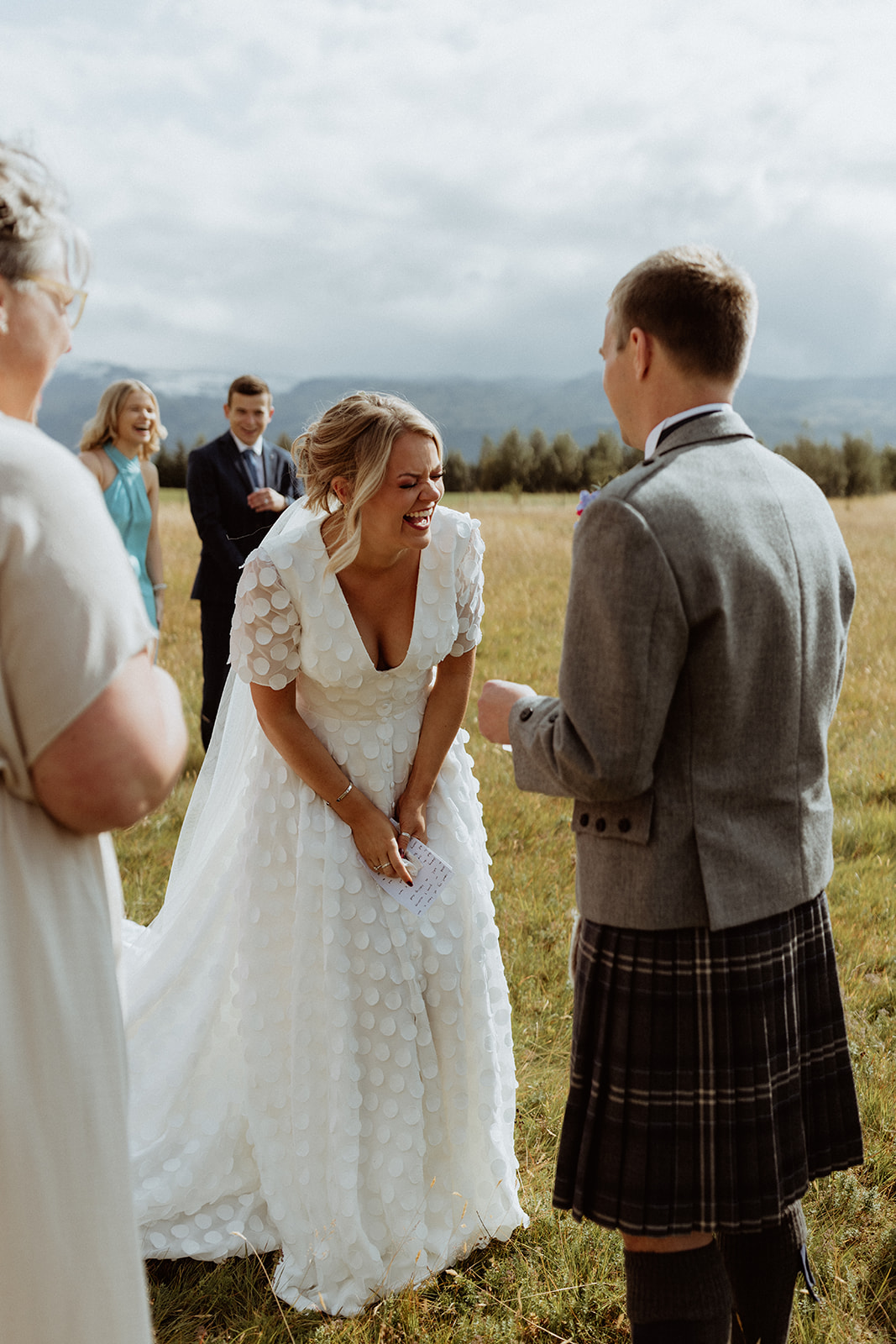 Bride and groom sharing a joyful moment filled with laughter during their Iceland elopement at Gluggafoss waterfall.