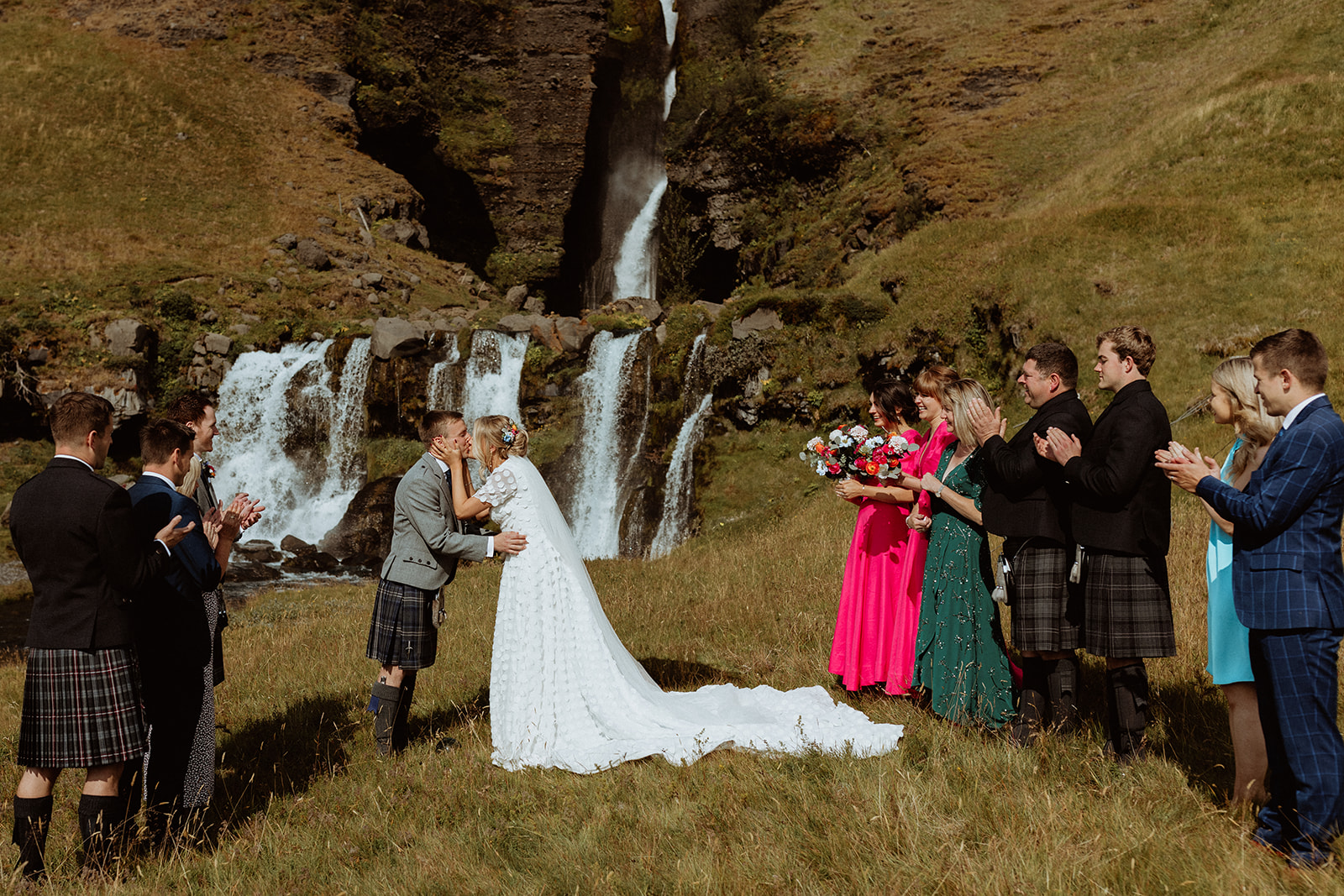 Bride and groom sharing their first kiss as newlyweds during their Iceland elopement at the stunning Gluggafoss waterfall.