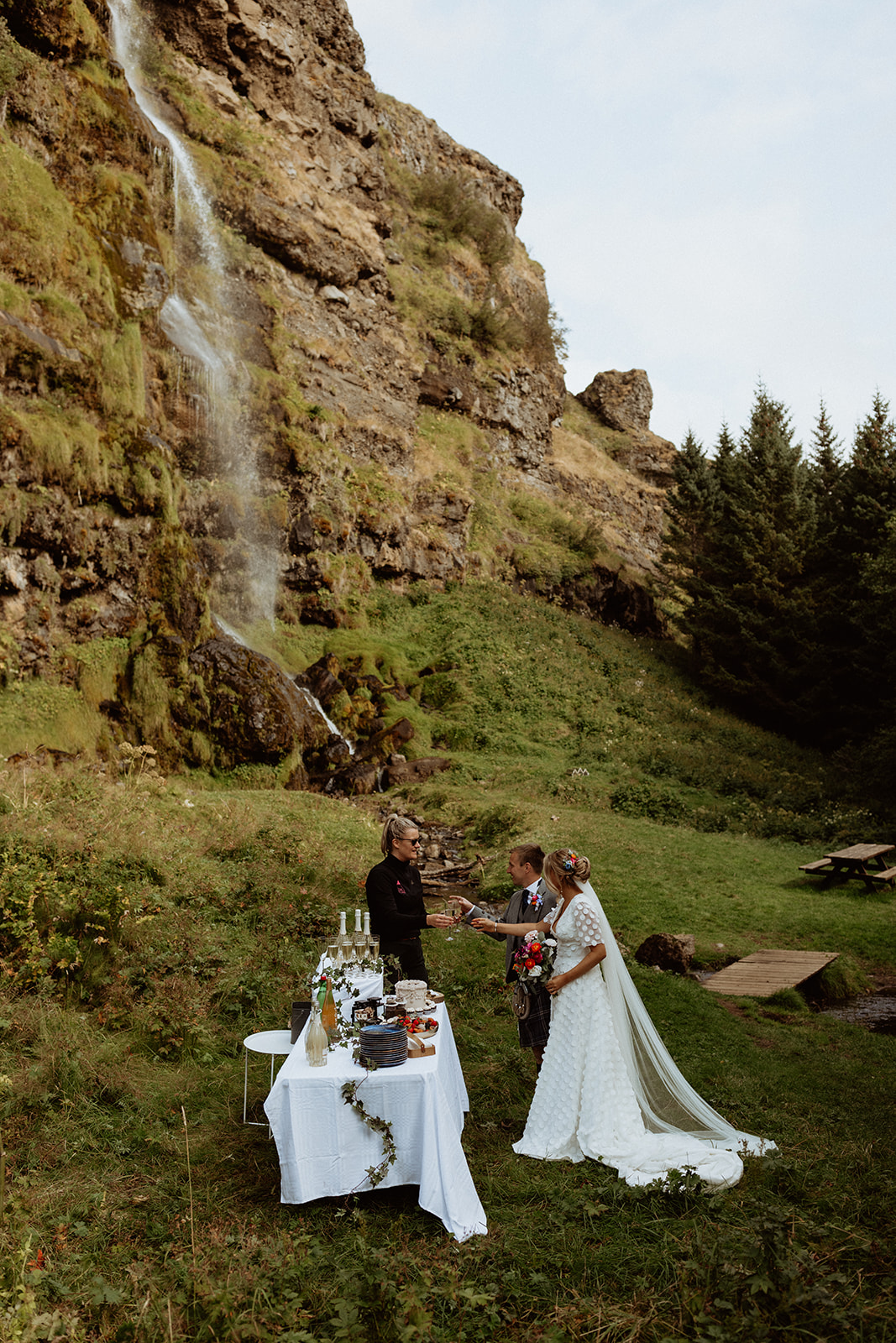 Bride and groom celebrate their Iceland elopement by receiving champagne at Thornsteins Grove, a special moment during their intimate day.