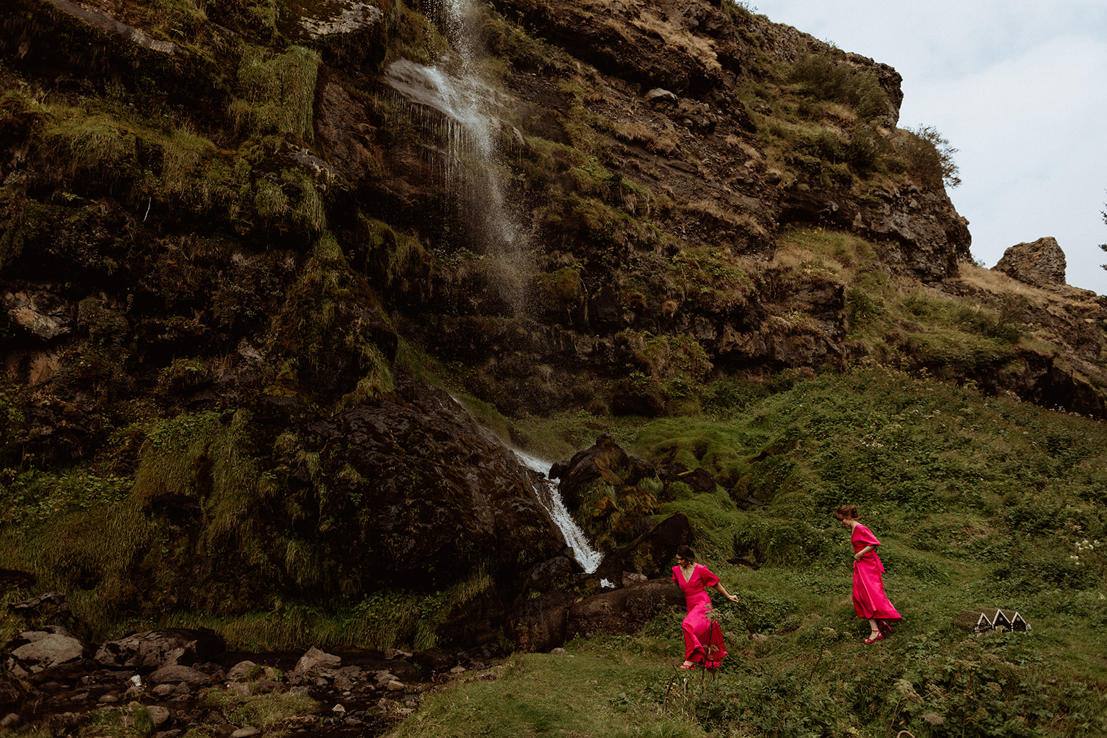 Bridesmaids running joyfully across the Icelandic landscape during the elopement at Thornsteins Grove.