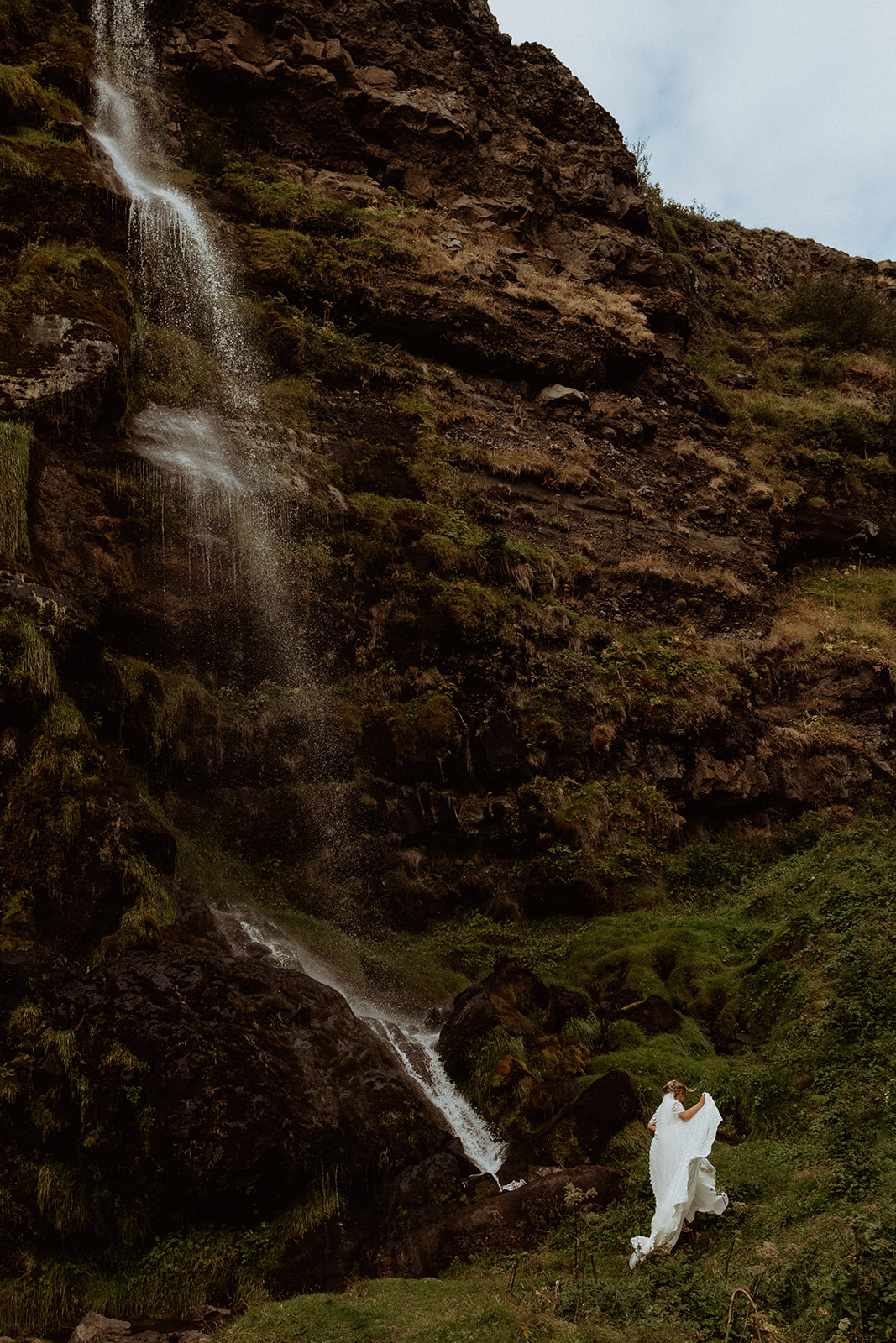 Bride and groom running and playing together in the Icelandic landscape during their adventure elopement at Thornsteins Grove.