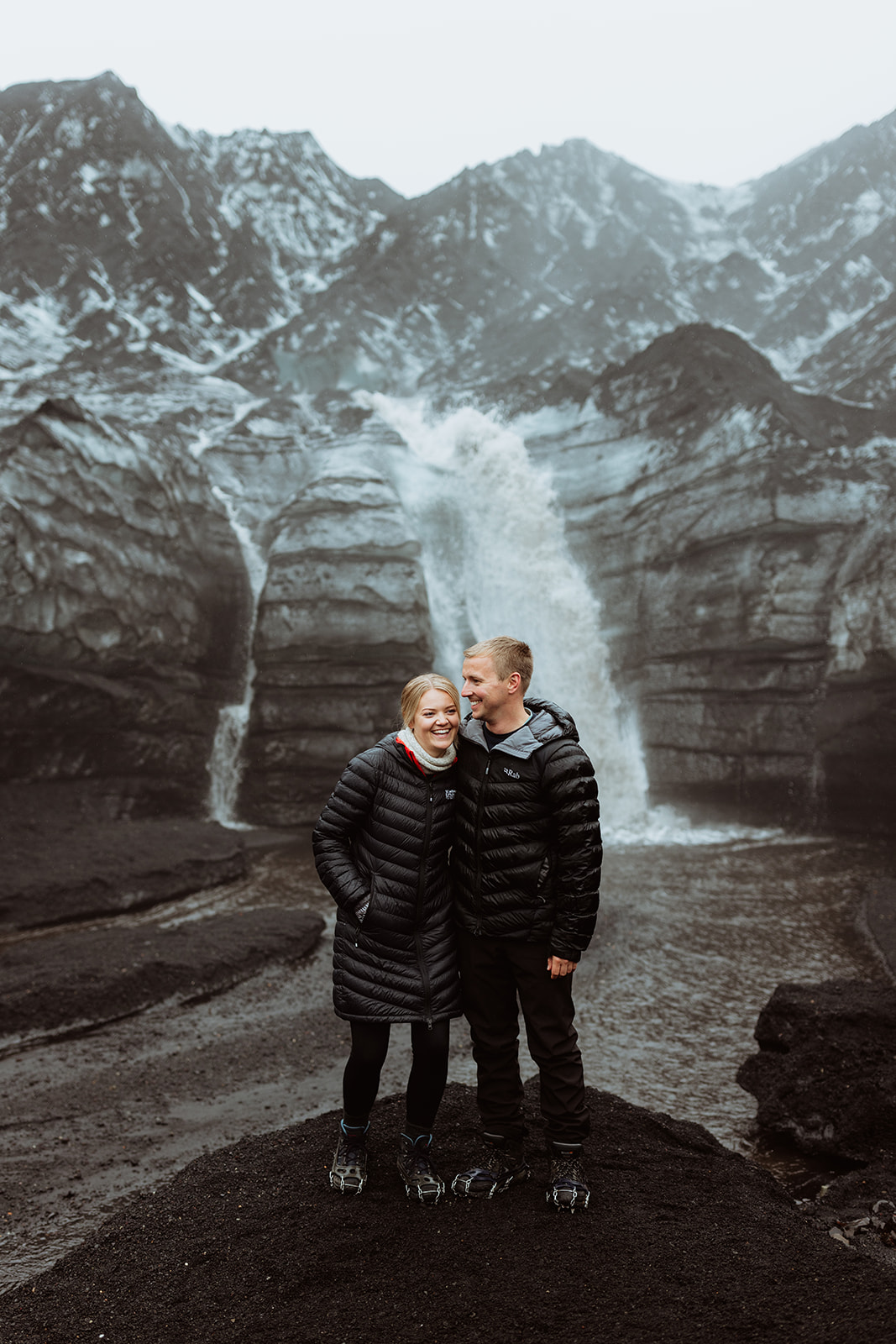 Amy and Tom standing together in the middle of a vast, snowy ice field on Katla glacier, taking in the overwhelming beauty of the landscape.