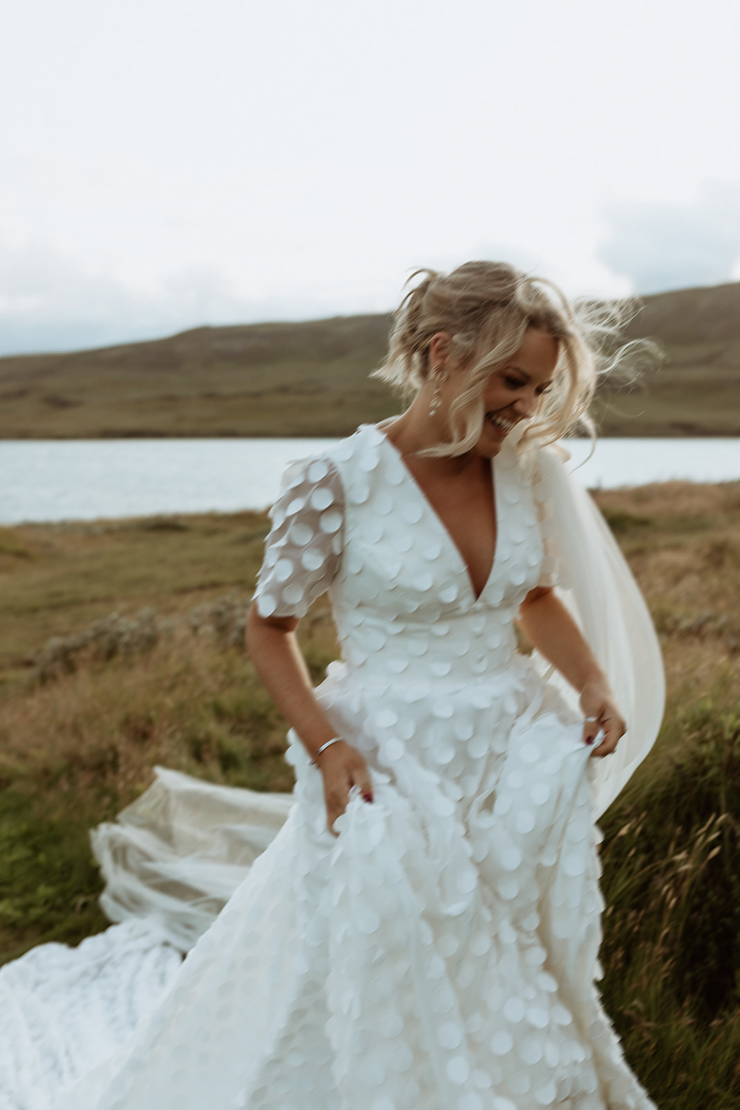 Bride in motion, running through the breathtaking Icelandic scenery, her wedding dress flowing freely in the wild wind, embracing the spirit of adventure and love