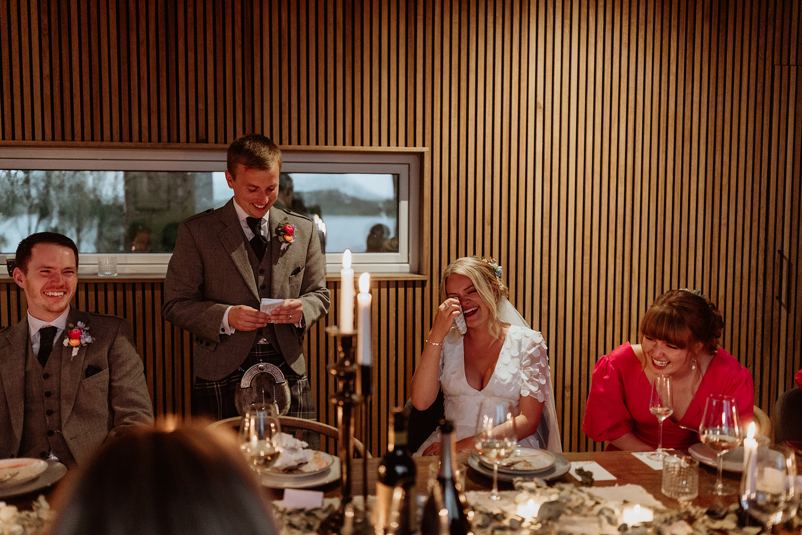 Emotional groom delivering heartfelt speech at the Icelandic elopement reception, with guests listening intently.
