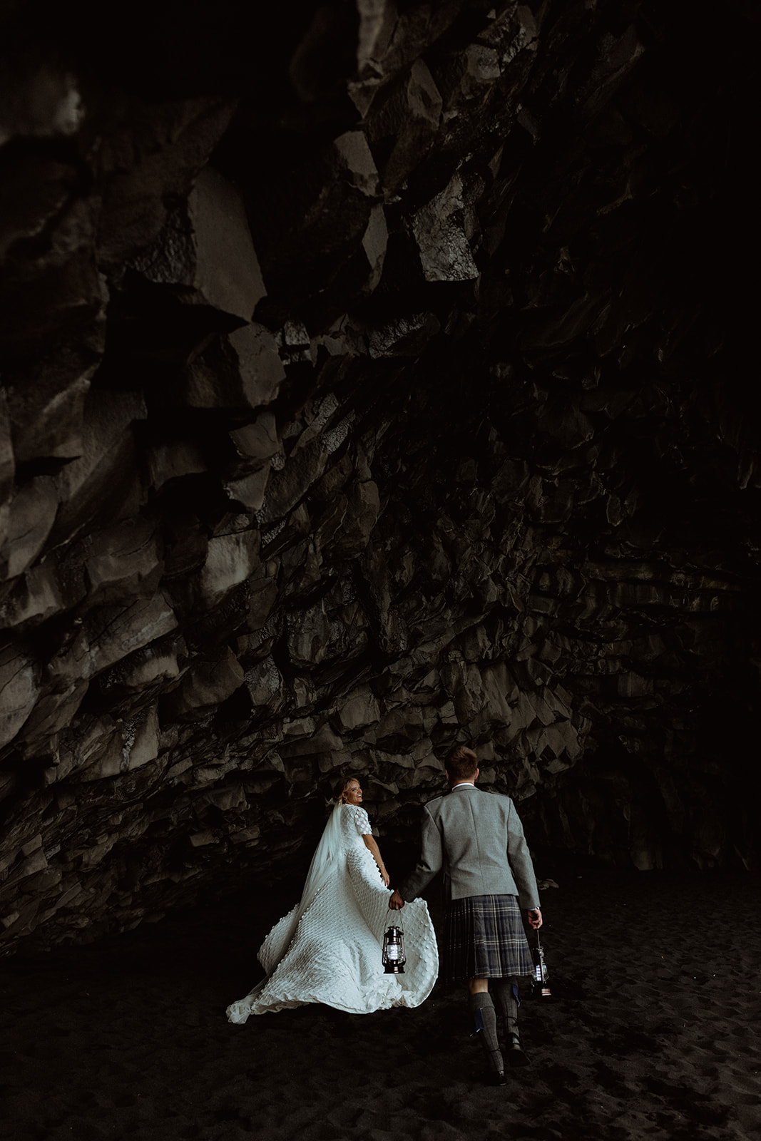 Amy and Tom explore the mysterious cave at Reynisfjara Beach, surrounded by dramatic rock formations and the sound of the waves crashing outside