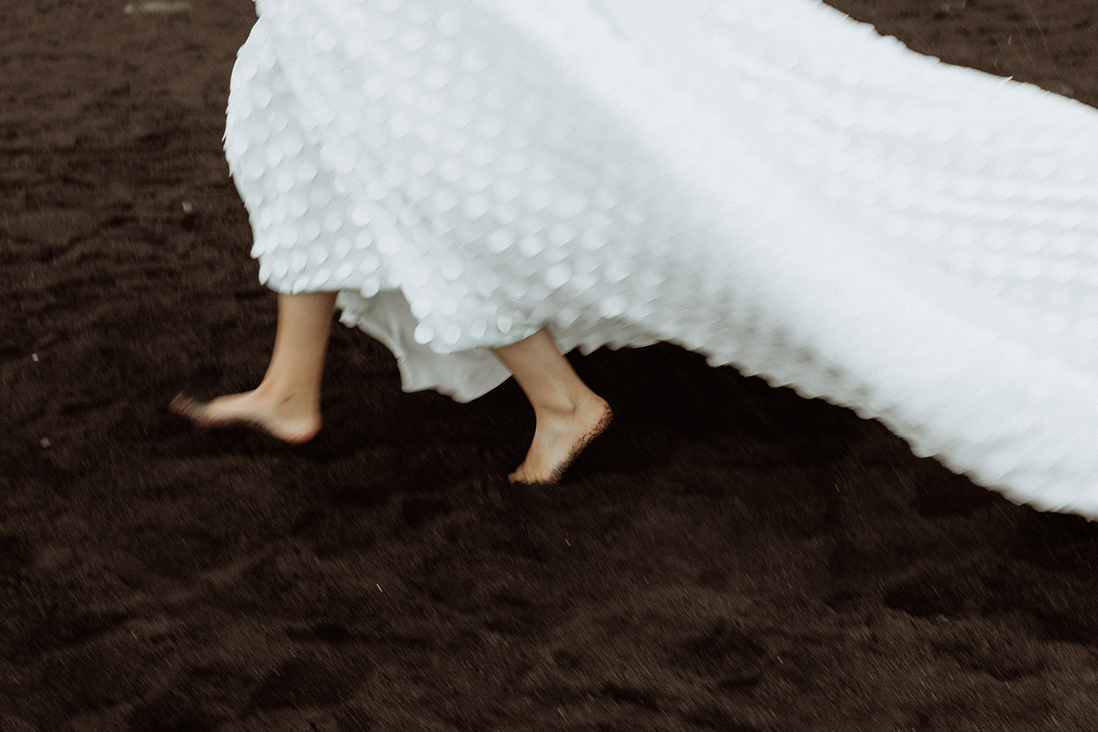 my walks barefoot on the black sand of Reynisfjara Beach, the waves gently lapping at her feet as she takes in the dramatic Icelandic landscape.