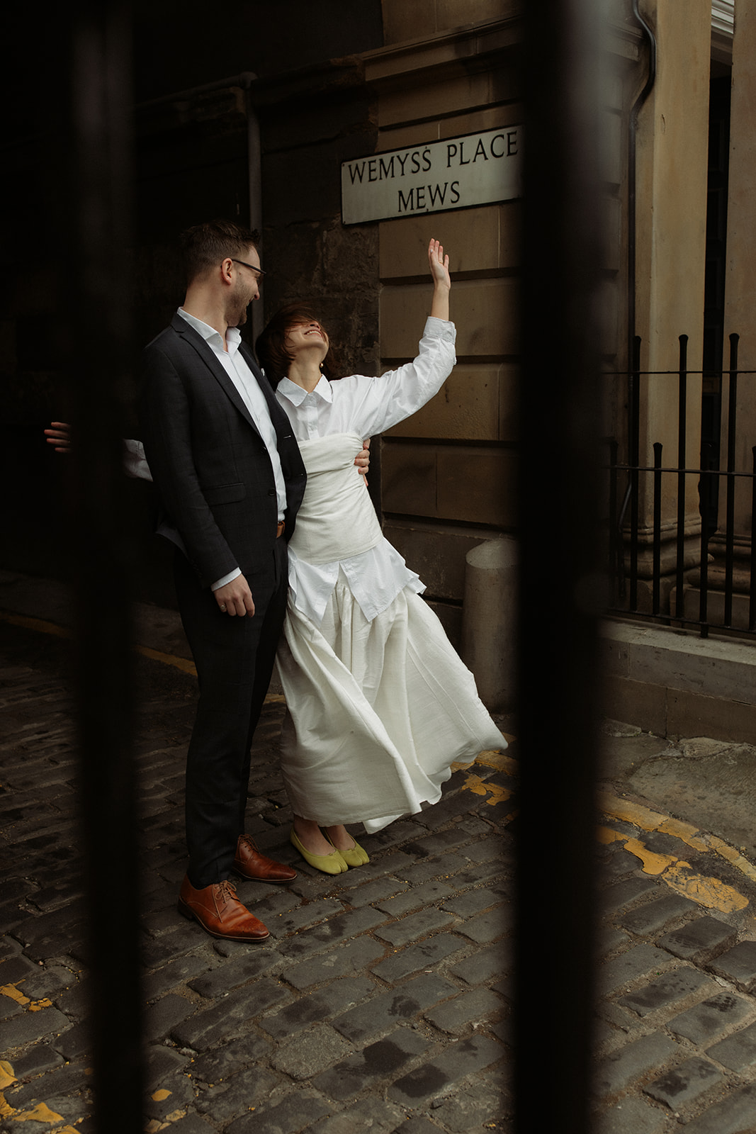 Editorial engagement photo in Edinburgh with a couple walking hand-in-hand through charming city streets