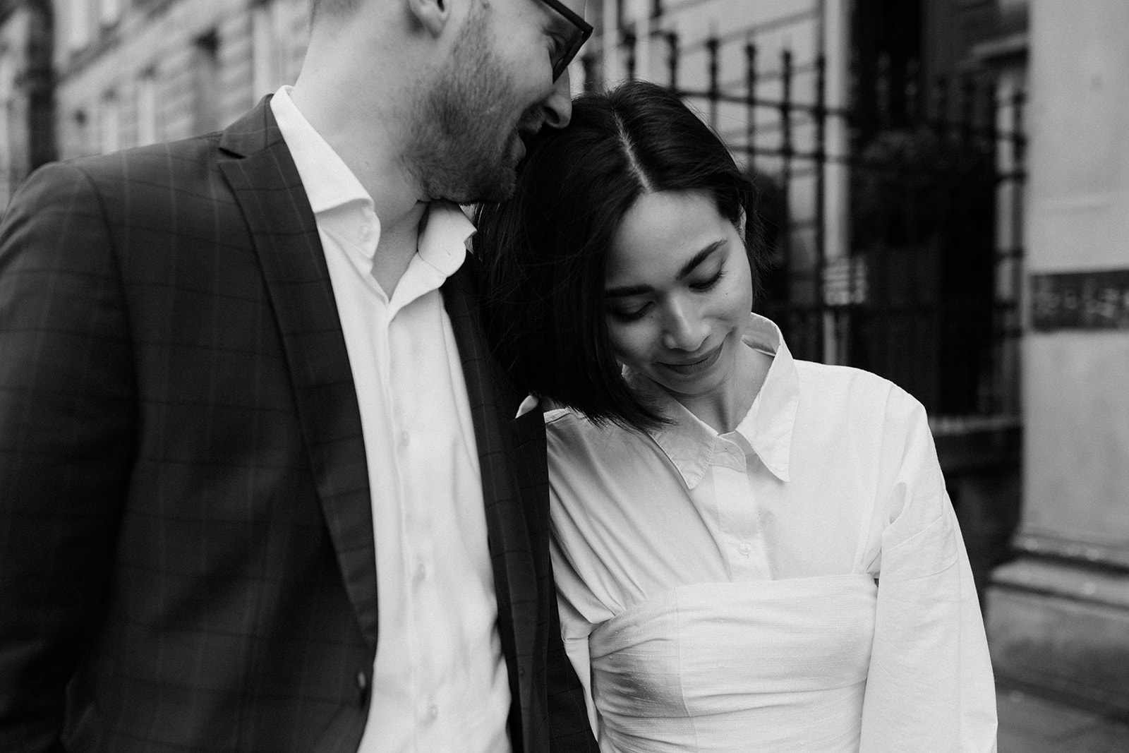 Candid moment from an editorial engagement session, capturing a couple walking through Edinburgh's scenic streets
