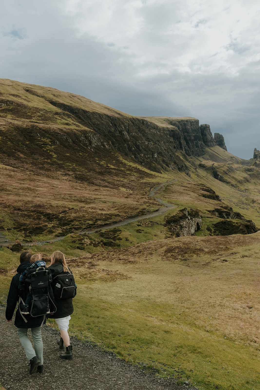 Eloping couple hiking on the Isle of Skye with their toddler in a backpack
