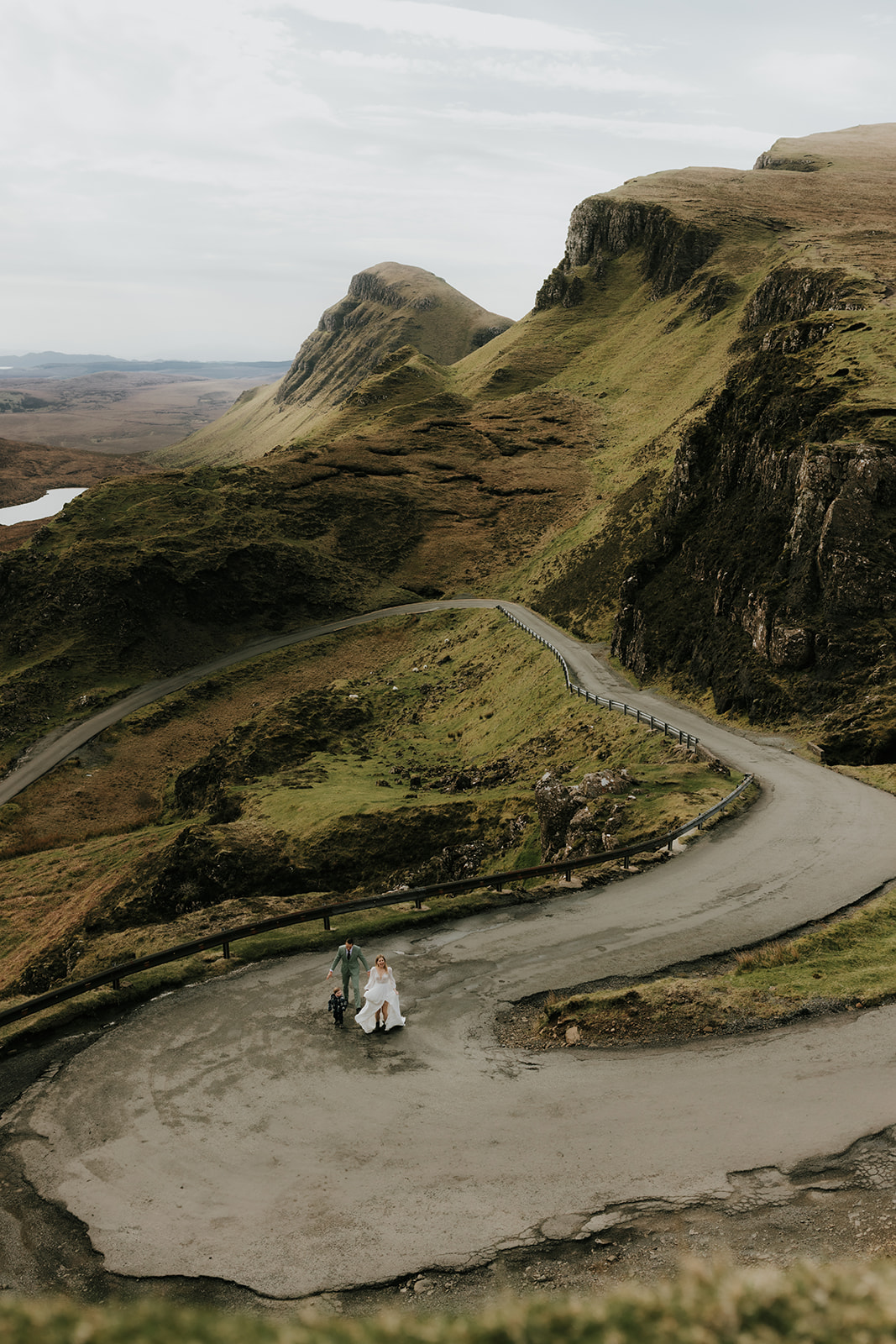 Couple walking hand in hand along a windy road on the Isle of Skye