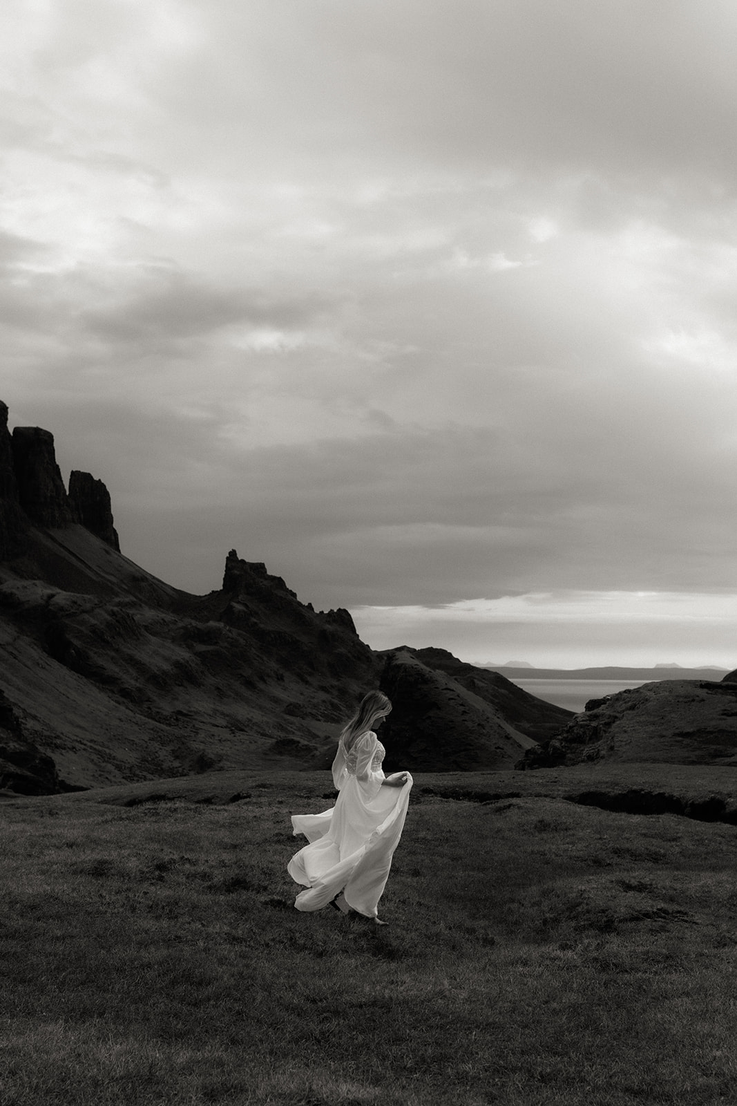 Bride walking along the Quiraing cliffs during Isle of Skye elopement.