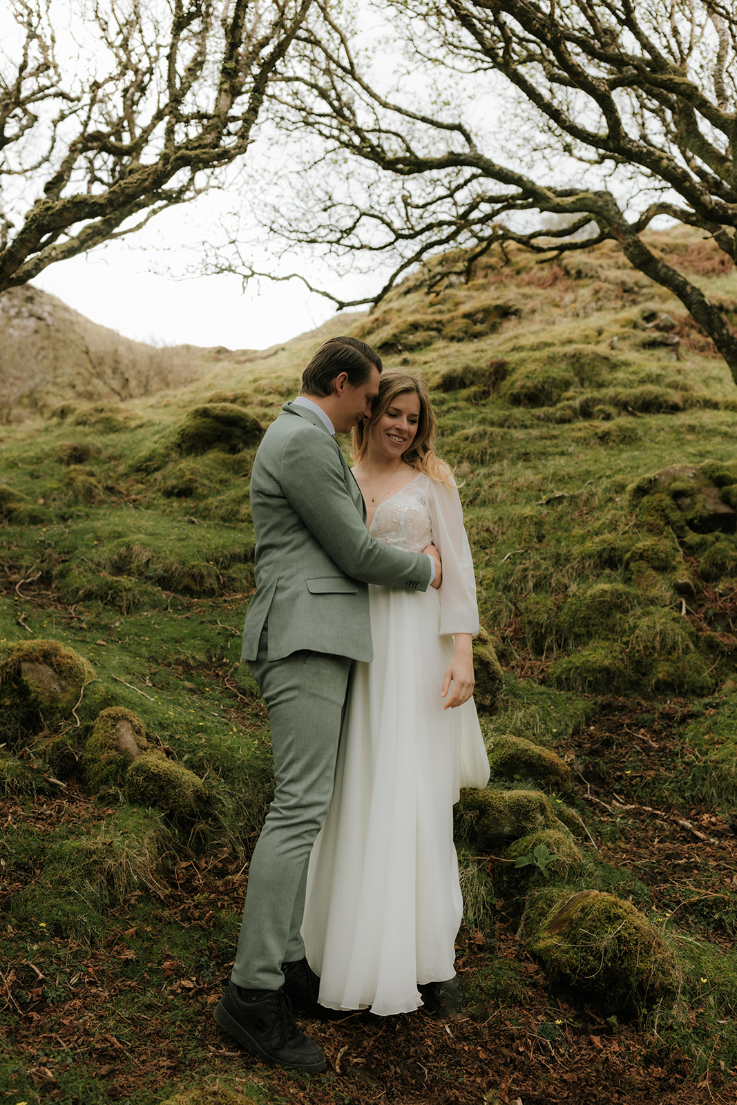 Couple embracing among trees at the Fairy Glen on the Isle of Skye