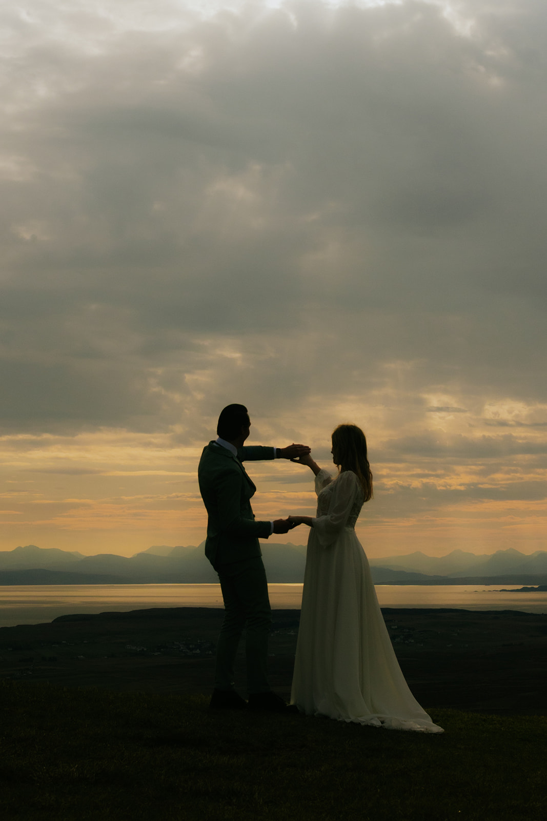 Silhouetted couple at sunrise on the Isle of Skye during their elopement