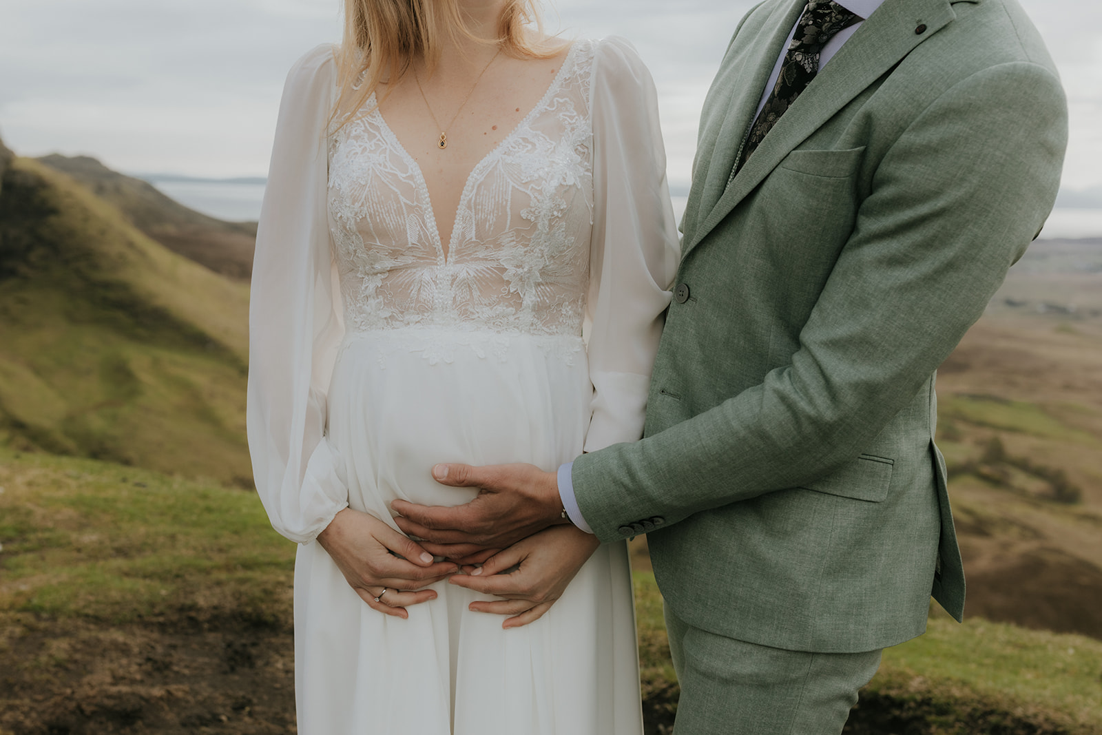 Bride and groom’s hands gently resting on baby bump during Isle of Skye elopement