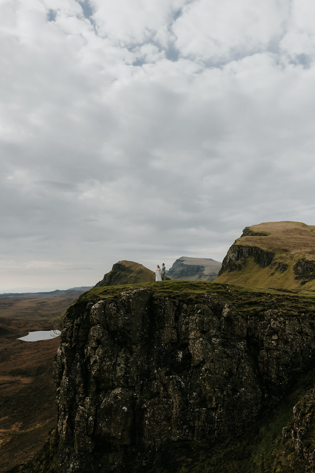 Couple standing together with wide panoramic views of the Quiraing on the Isle of Skye