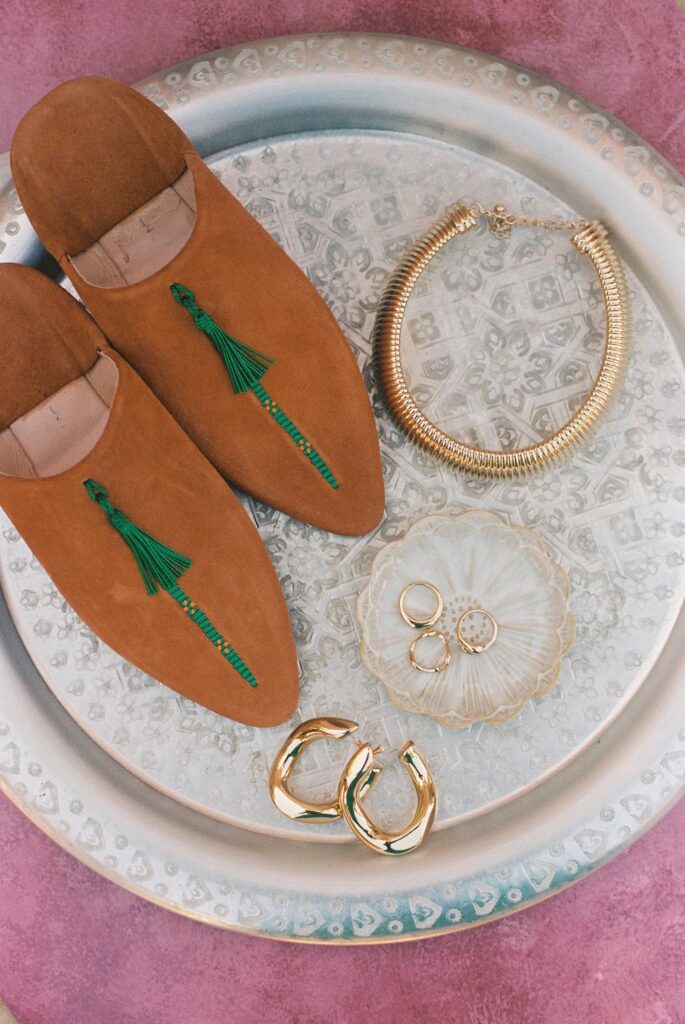 Traditional Moroccan slippers and gold wedding jewellery styled for a destination wedding, 35mm film.