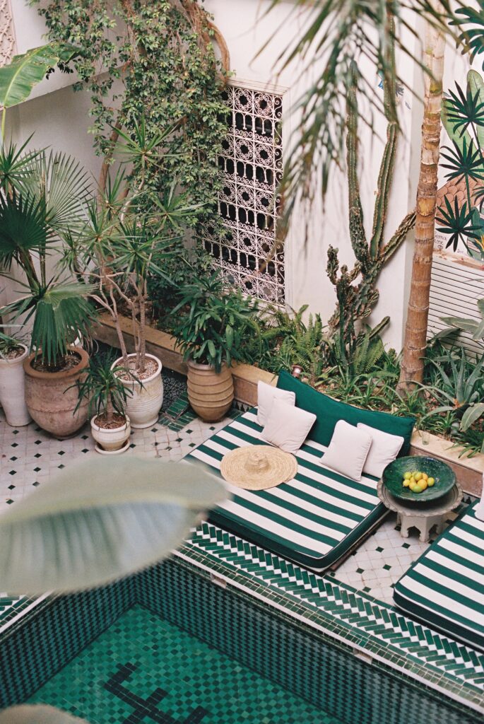 Aerial view of Le Riad Yasmine pool and striped loungers in Marrakesh, 35mm film.
