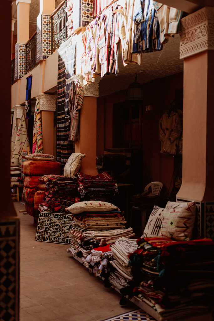 Moroccan rug shop entrance with stacks of rugs inside