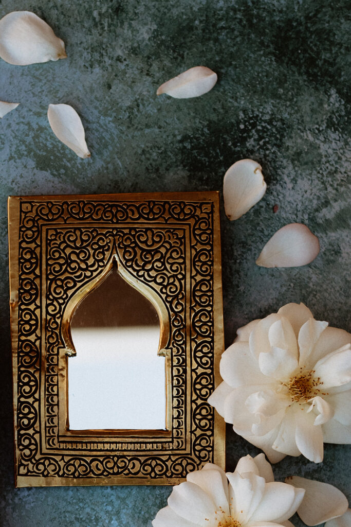 Ornate Moroccan archway with white flower petals scattered below
