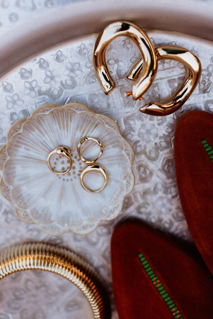Wedding rings and shoes on a white textured background in Marrakesh