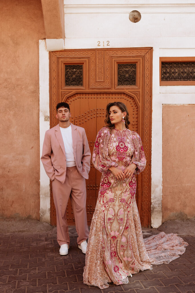 Couple standing in front of ornate wooden door in Marrakesh