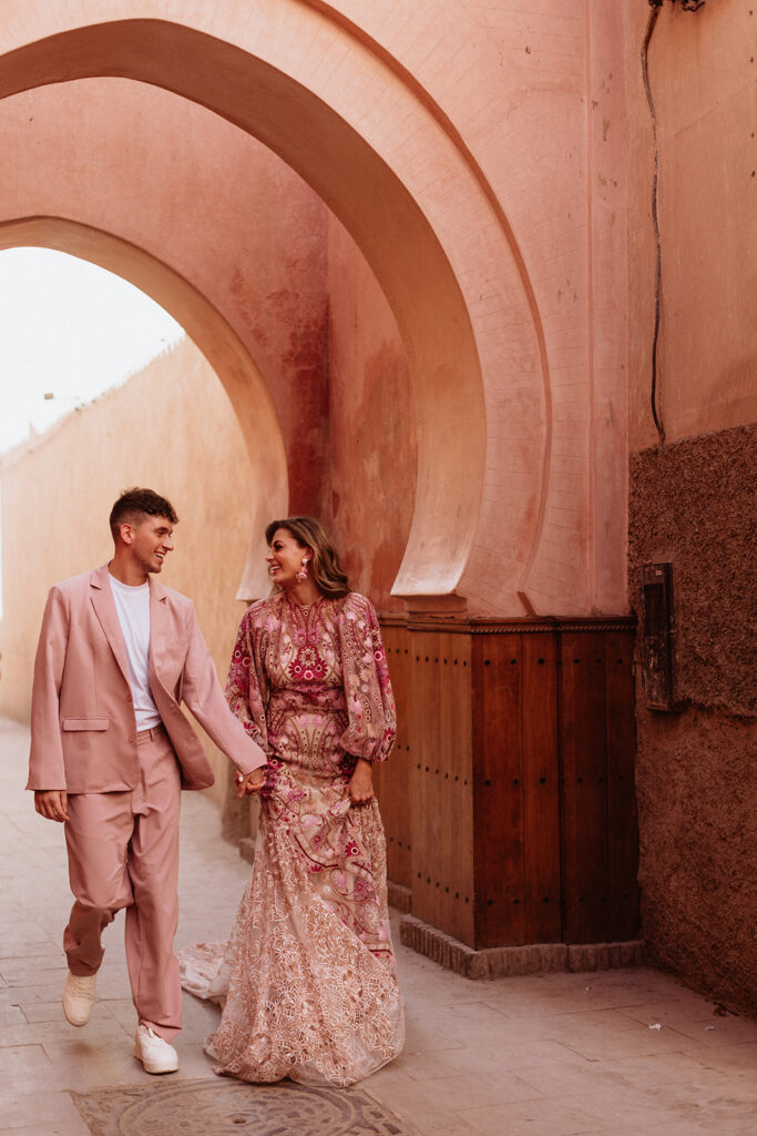 Bride and groom walking hand in hand through the Medina streets of Marrakesh.