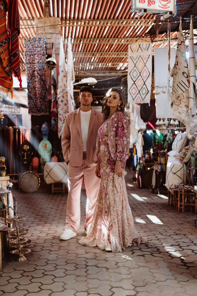 Bride and groom framed by textured walls and warm light in a Marrakesh market