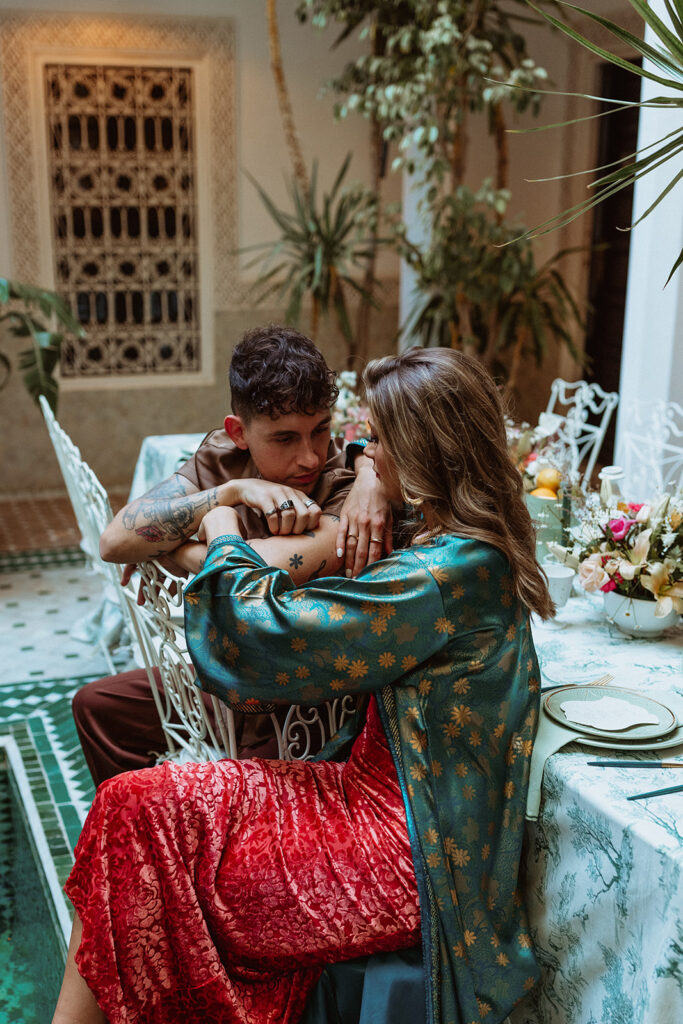 Bride and groom seated together at an opulent Moroccan courtyard table