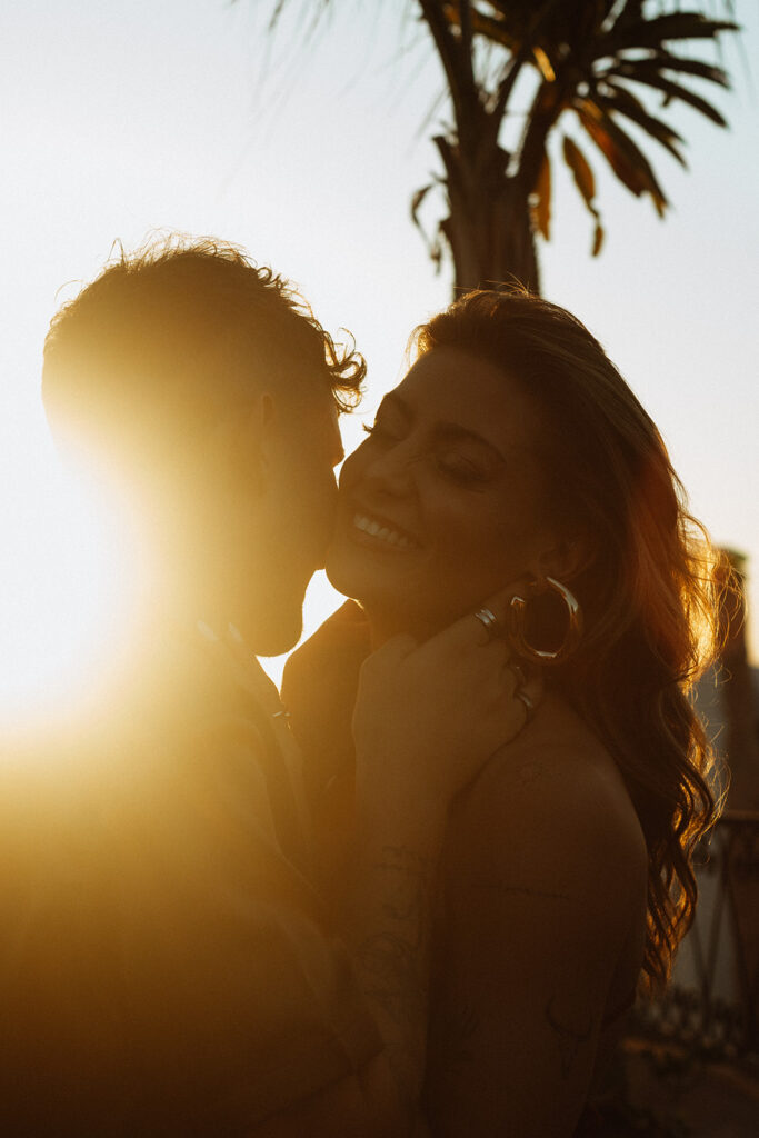 Bride and groom laughing together in golden hour light
