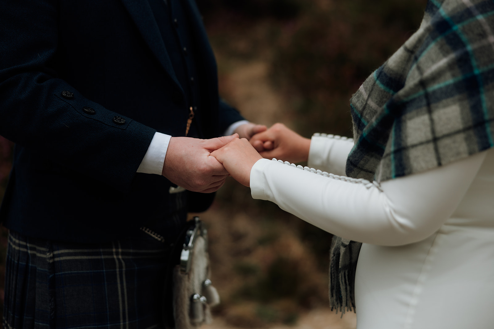 Groom placing ring on bride’s hand during Isle of Arran elopement ceremony.
