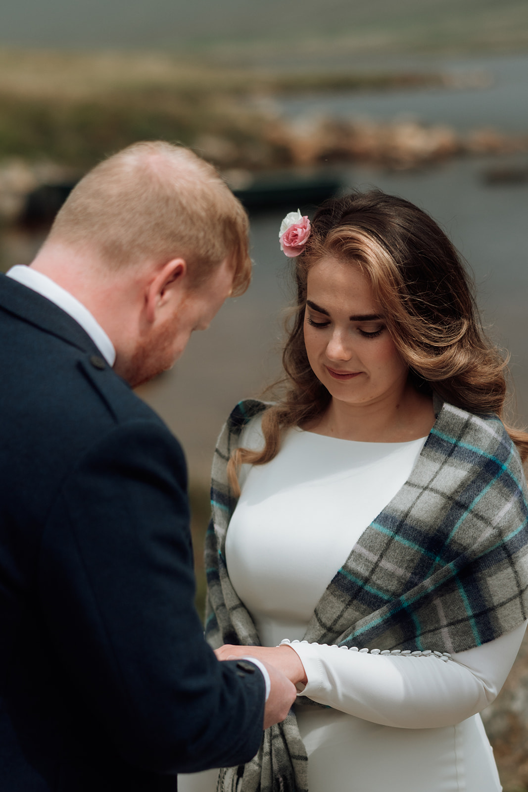 Bride in tartan shawl reading vows during Isle of Arran elopement at Loch Iorsa.