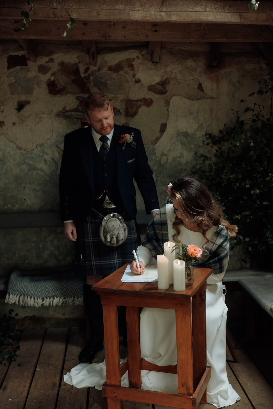 Bride and groom signing marriage documents during Isle of Arran elopement.