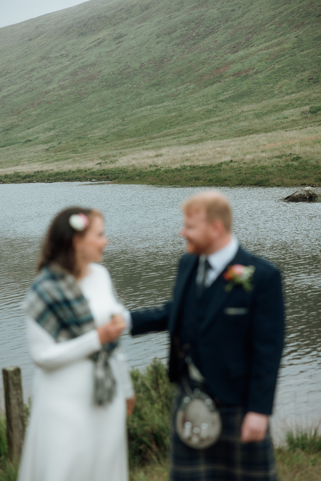 Bride and groom drinking together beside Loch Iorsa during Isle of Arran elopement.