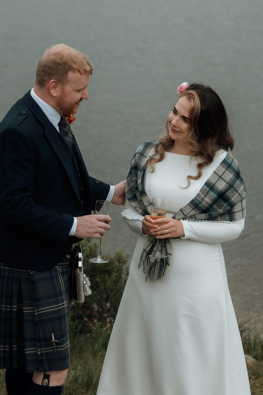 Groom pouring champagne for bride during Isle of Arran elopement.