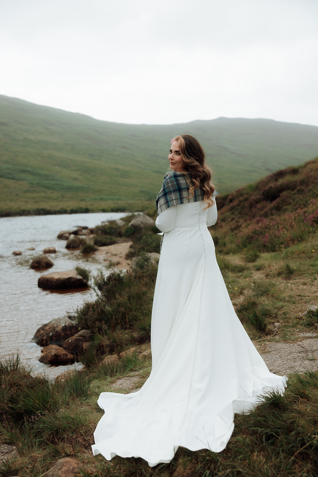 Bride in tartan shawl standing by Loch Iorsa, Isle of Arran.