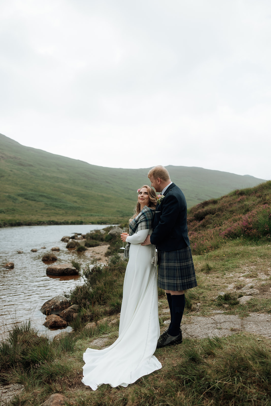 Bride and groom standing close by the loch at Isle of Arran elopement.