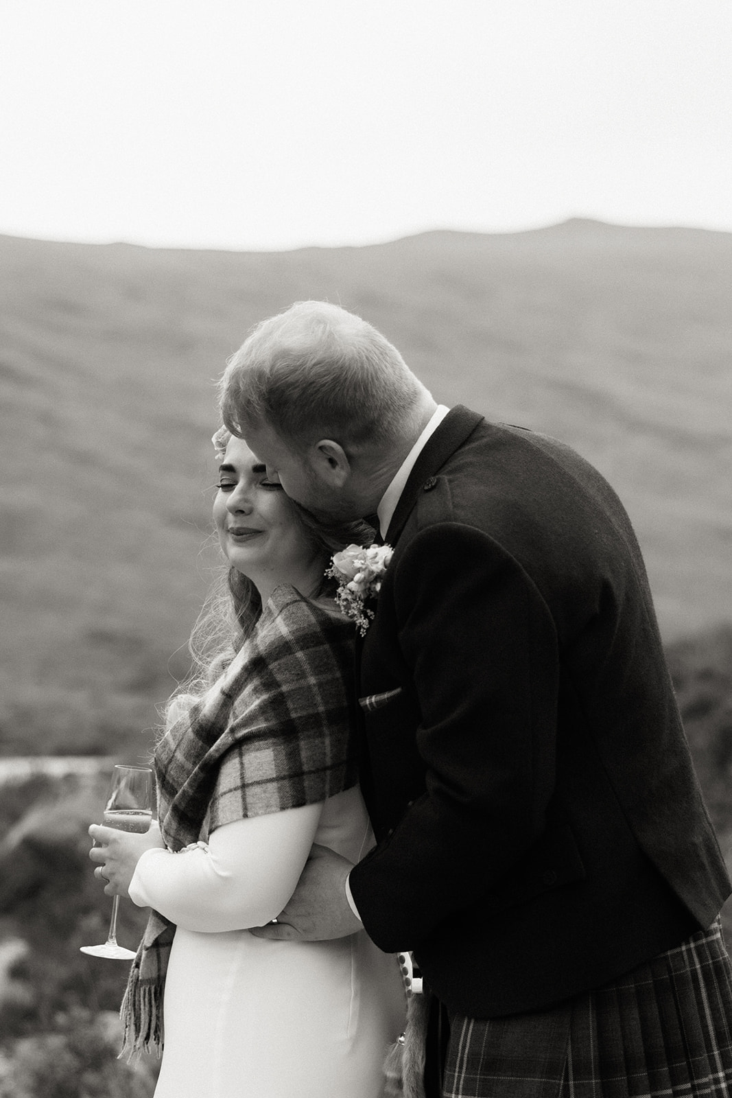 Black and white photograph of bride and groom embracing during Isle of Arran elopement.