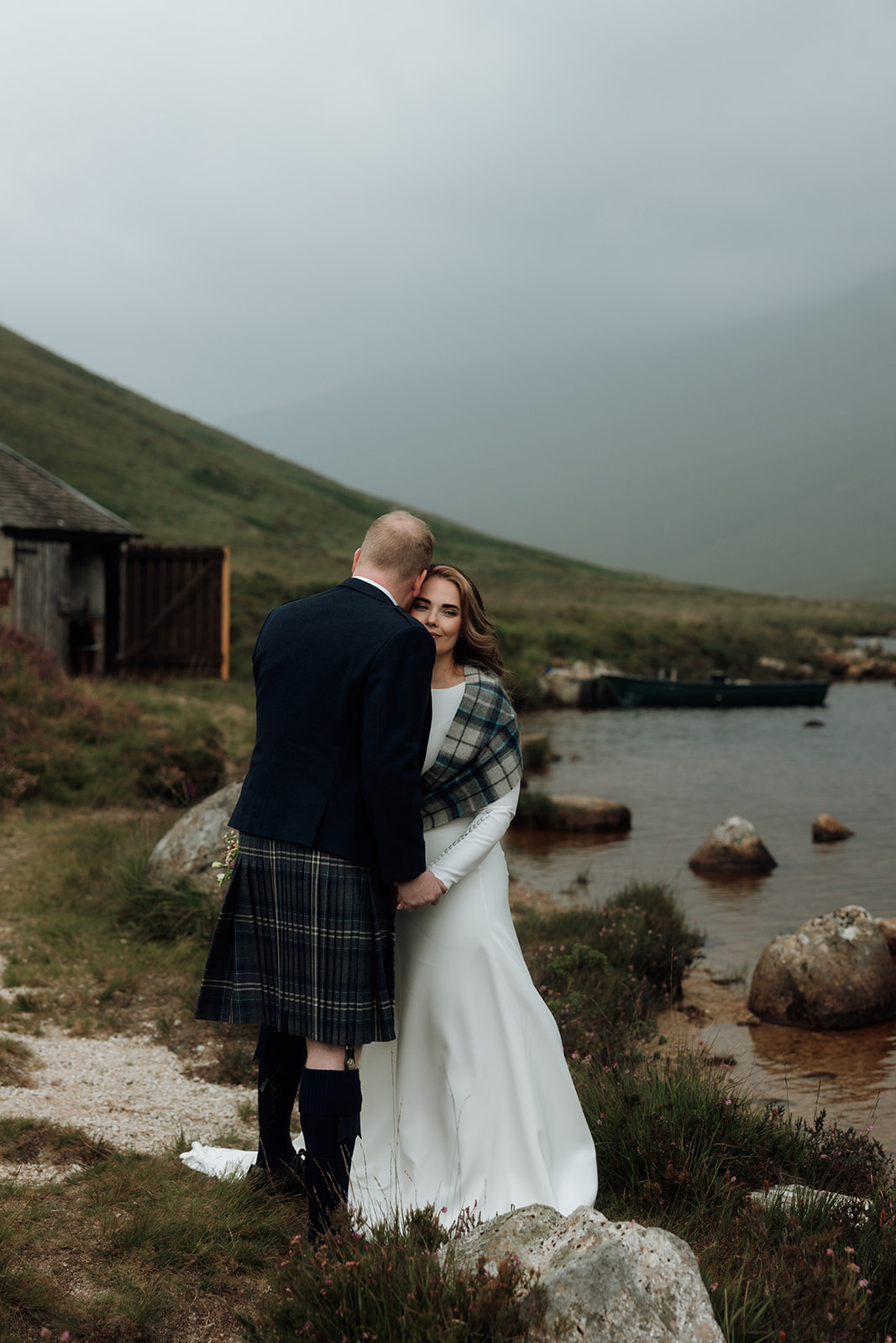Bride and groom standing together by Loch Iorsa, Isle of Arran.