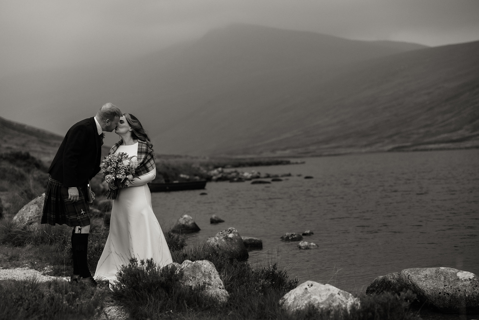 Black and white photo of bride walking beside Loch Iorsa during Isle of Arran elopement.