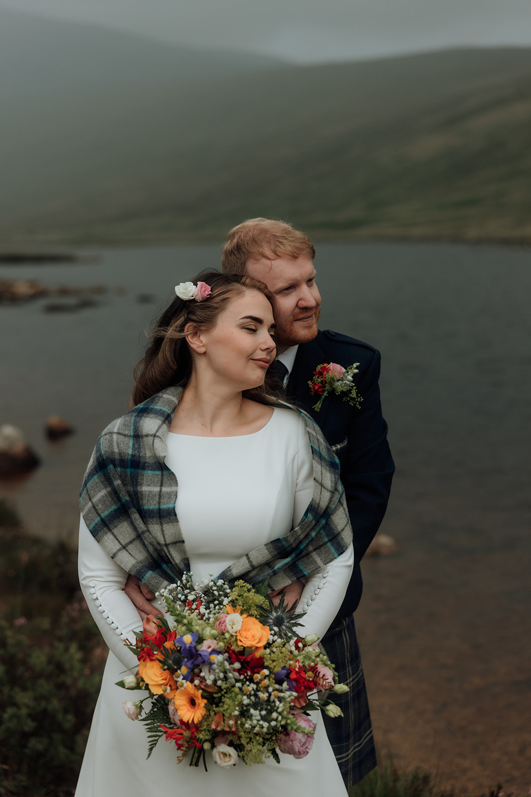 Bride with colourful bouquet looking to the side during Isle of Arran elopement.