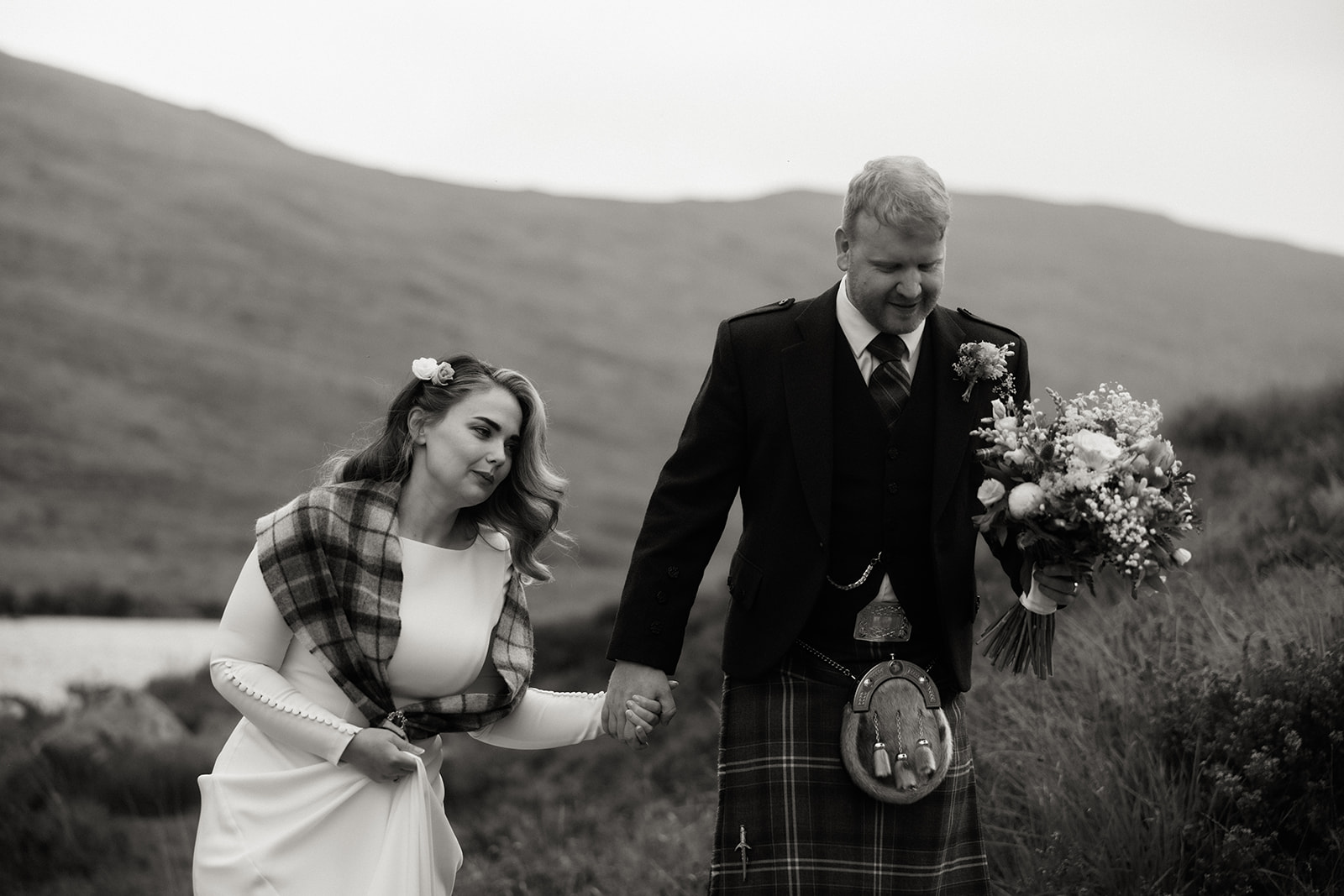 Black and white photo of bride and groom walking together during Isle of Arran elopement.